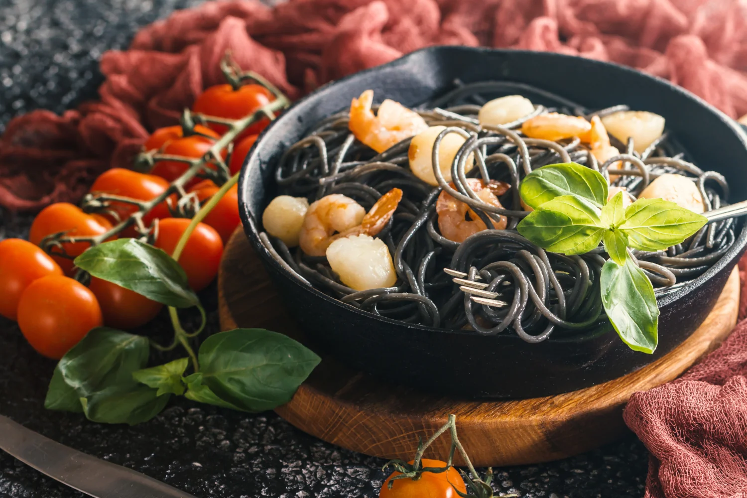 A bowl of dramatic black squid ink spaghetti twirled with plump shrimp and tender scallops, coated in a rich garlic-infused butter sauce